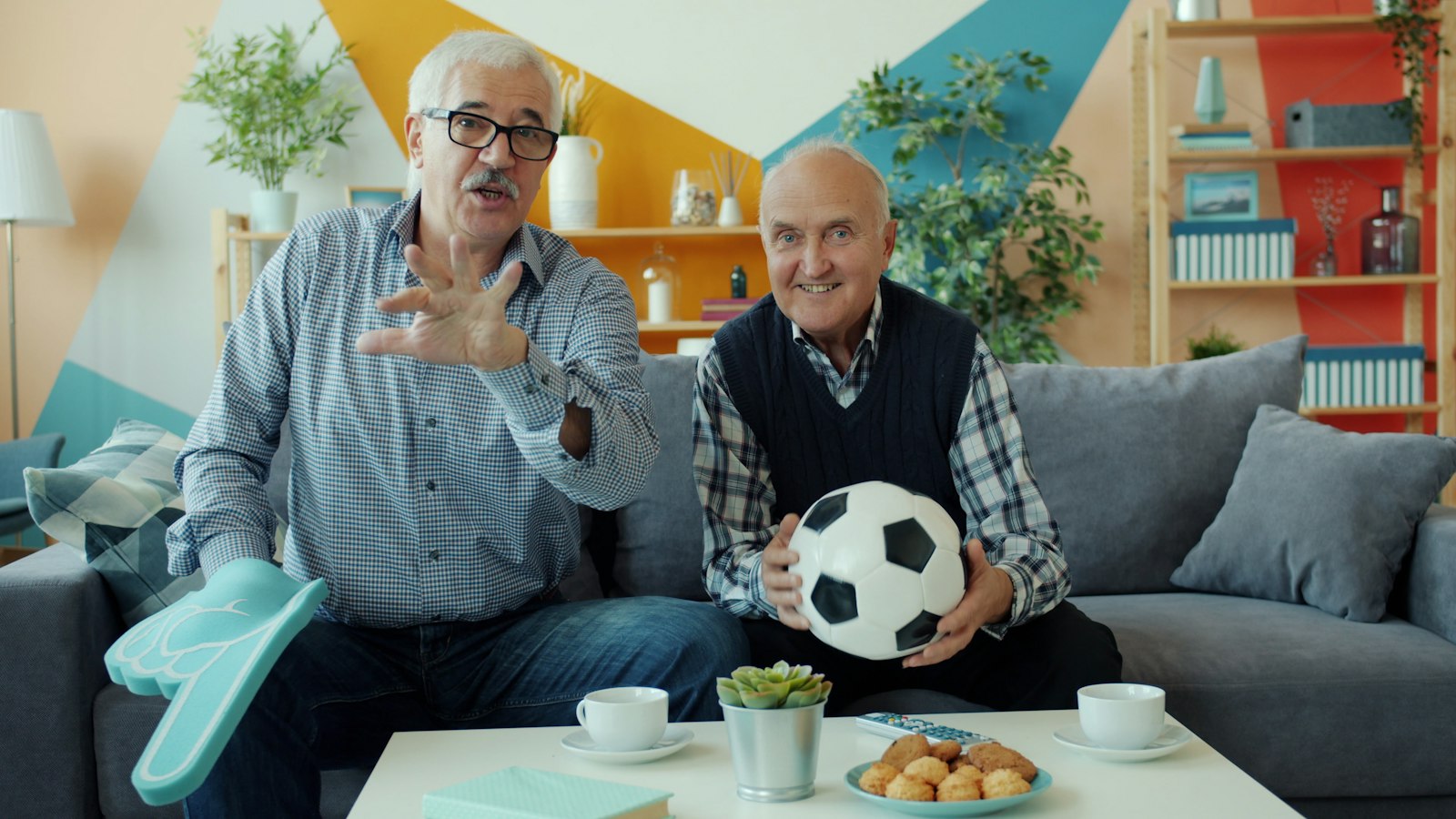 Twee mannen kijken samen voetbal op tv