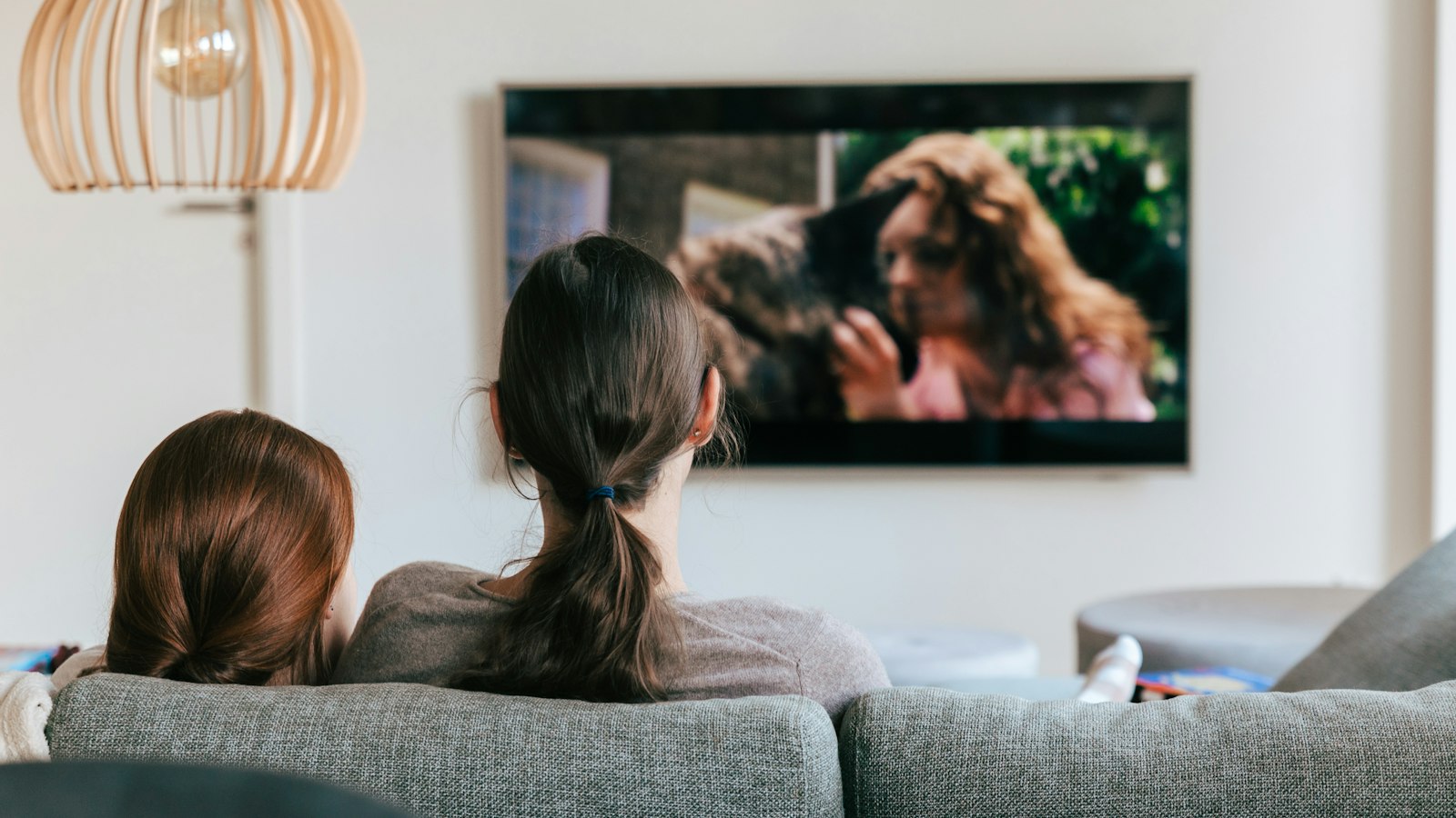 Zwei Personen auf dem Sofa schauen fern