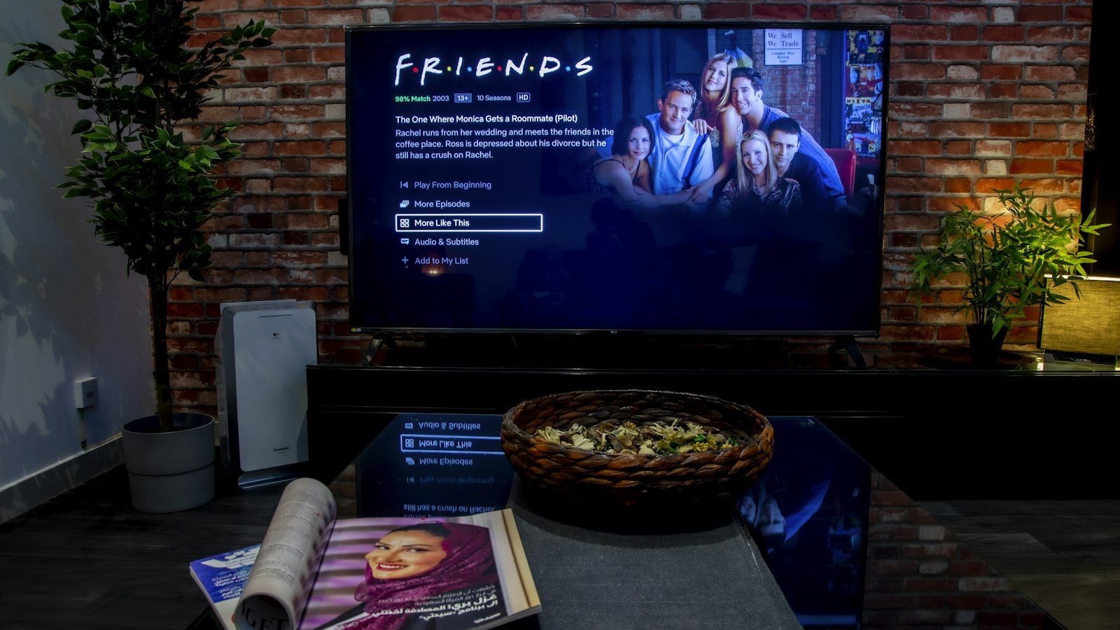 Ingeschakelde tv aan een bakstenen muur in een woonkamer